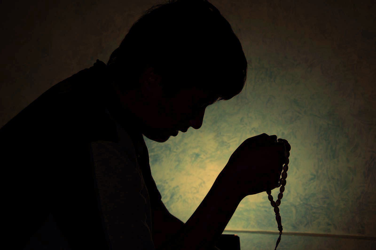 Человек молится в темноте